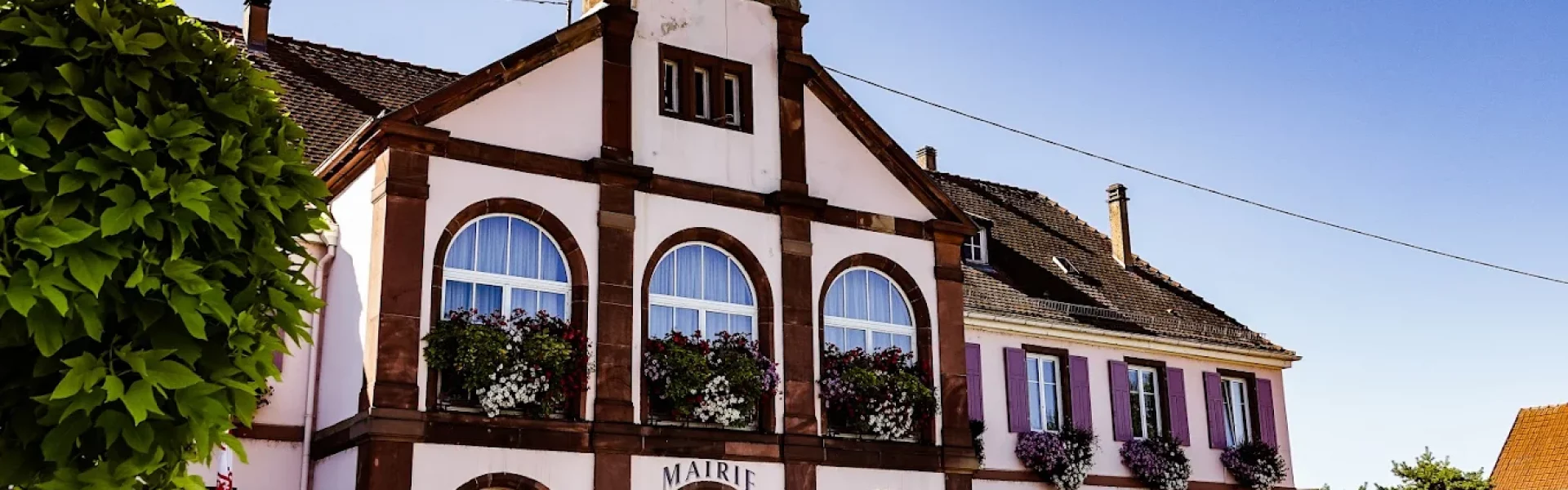 Mairie d'Eschau avec son clocheton, ses arcades et ses volets mauves.